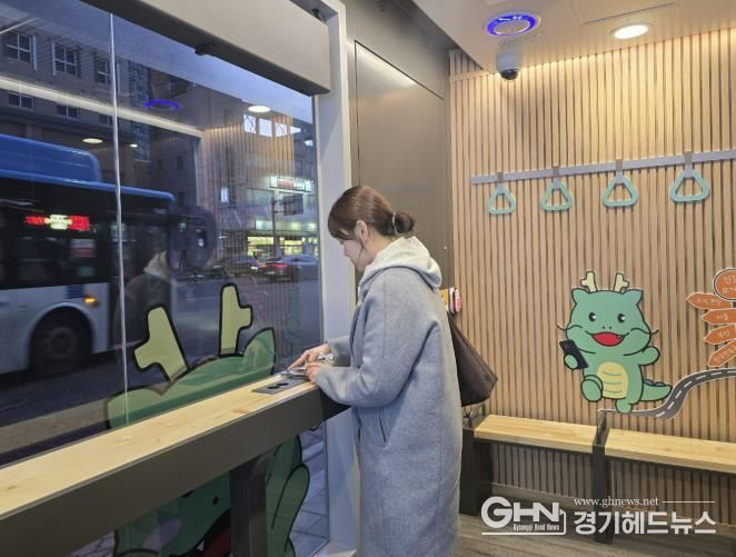 한 시민이 신갈오거리에 새로 설치한 '스마트 버스 쉼터' 안에서 휴대폰을 충전하고 있는 모습