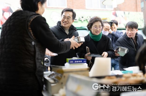 26일 오후 김동연 경기도지사와 정우영 배우자가 설맞이 의왕도깨비시장 방문하여 구매한 전을 다회용기에 포장하고 있다.