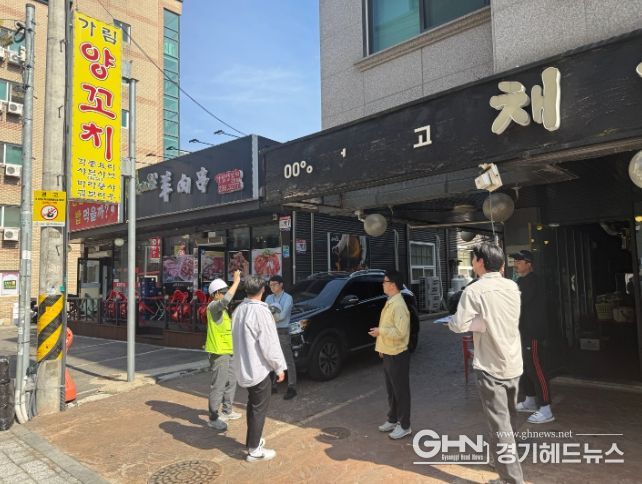 정명조 건축과장과 관계자들이 도로변 상가 간판의 안전 상태를 확인하며 현장점검을 하고 있다.